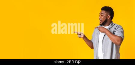 Cool Offer. Cheerful Black Guy Pointing Aside At Copy Space Stock Photo
