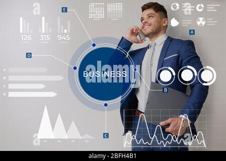 Business man talking on smart phone with holographic graphs Stock Photo
