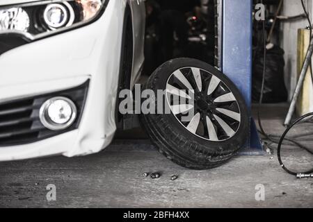 Changing car wheel in auto, car service with lifted vehicle, service center, changing tires Stock Photo