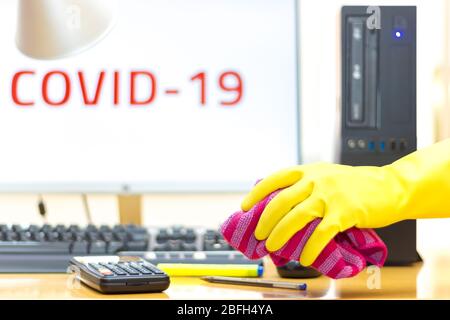 Disinfecting of an office with spray and glove to prevent COVID-19 disease Stock Photo