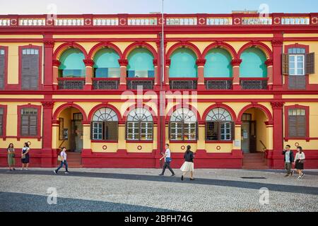 People walking by the colourful building of the Macao Central Library. Macau, China. Stock Photo