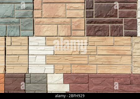 Facade panels with texture of stone wall for exterior decoration of various colors and sizes are geometrically arranged. Abstract background for your Stock Photo