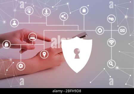 Woman holding phone with virtual security shield Stock Photo
