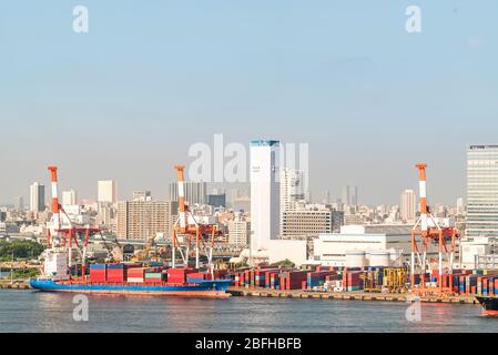 Big Cargo Containers Boat with Goods cargo Stack at the Pier docks port waiting for international sea freight transportation import and export in Toky Stock Photo