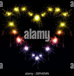 heart-shaped sparklers on black background Stock Photo