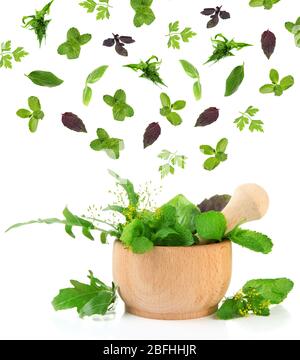 Herbs falling into mortar, isolated on white Stock Photo
