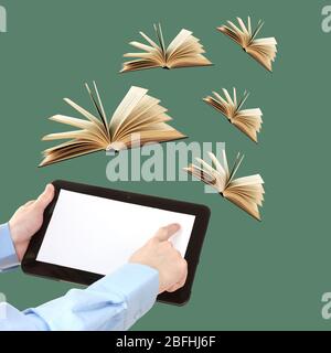 Tablet and opened books on green background Stock Photo