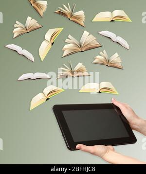 Tablet and opened books on grey background Stock Photo