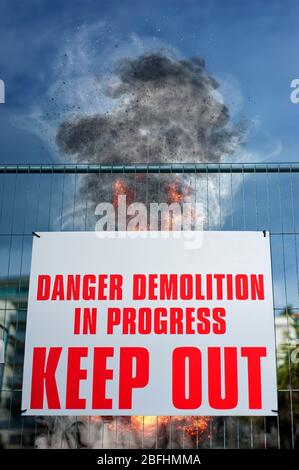 Danger Demolition in Progress Keep Out sign with Building Undergoing Demolition by controlled explosion in the background. Brighton, United Kingdom