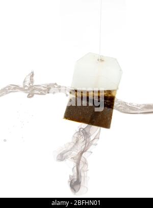 Tea bag dipped in hot water Stock Photo