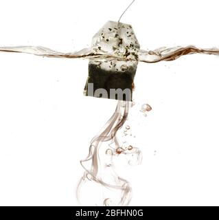 Tea bag dipped in hot water Stock Photo