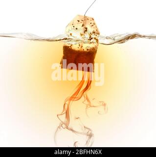 Tea bag dipped in hot water Stock Photo