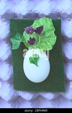 Deko Osterei mit Eierschachteln als Hintergrund