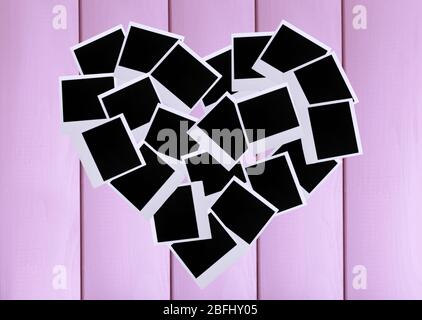 Photo papers in shape of heart on wooden background Stock Photo