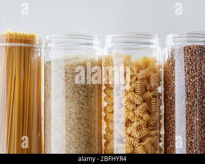 Various pasta and cereal grains in plastic jars for a long storage. Stock Photo