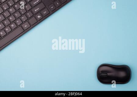 Flat lay flatlay top above overhead close up view photo of black computer wireless mouse and keyboard isolated over blue background with empty blank s Stock Photo