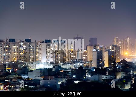 Aerial panorama shot of buildings skyscrapers with offices and residences with lights on at night Stock Photo