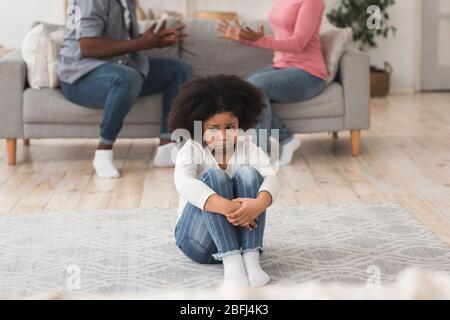 Innocent little african american girl suffering from family conflicts Stock Photo