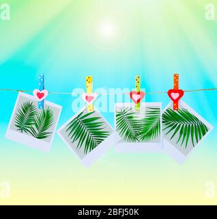 Photo cards hanging on clothesline on color background Stock Photo
