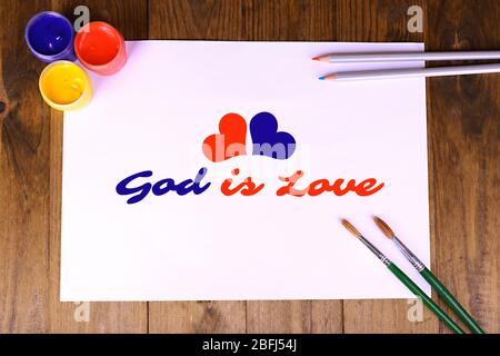 God is Love text on paper on wooden table background Stock Photo
