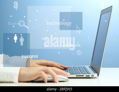 Businesswoman using laptop with digital layer effect on blue background Stock Photo