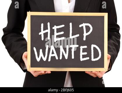 Young businesswoman holding blackboard with Help Wanted text on it Stock Photo