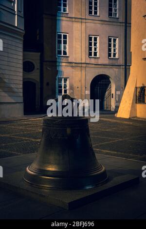 Vintage evening look of the Old Town in city of Warsaw, Poland, bronze Wishing Bell on the Kanonia Square, cast in 1646. Stock Photo