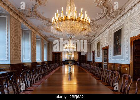 Large antique wooden table under a crystal chandelier in a historic hall of a royal palace in Copenhagen, Denmark Stock Photo