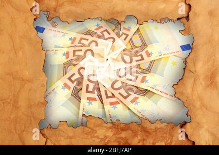 Euro banknotes through torn craft paper Stock Photo