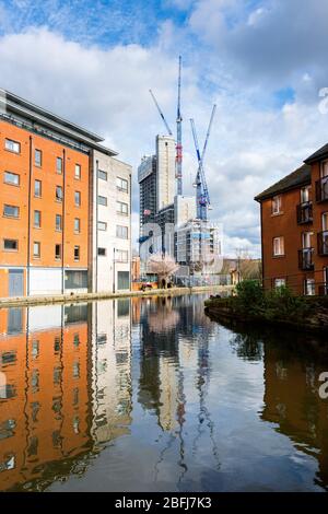 The Oxygen Tower apartment block (under construction) from Paradise Wharf on the Ashton Canal, Manchester, England, UK Stock Photo