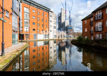 The Oxygen Tower apartment block (under construction) from Paradise Wharf on the Ashton Canal, Manchester, England, UK Stock Photo