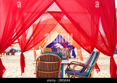 empty cafe with many colored canopy, baldachin tunnel looling on the seashore close to water in summer, India, Goa. Interior on summer restaurant on t Stock Photo