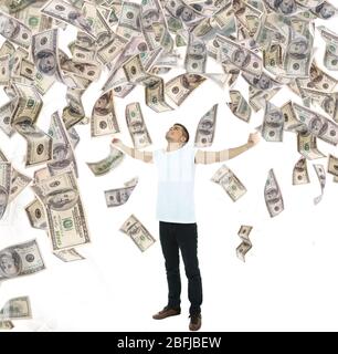Young man standing in rain of money Stock Photo