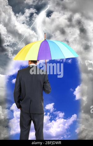 Business man standing in rain with umbrella Stock Photo
