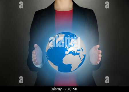 Female hands showing globe on dark background Stock Photo