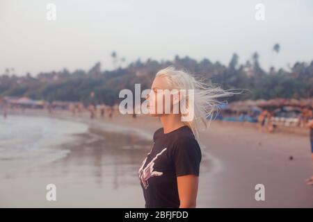 Beautiful profile portrait young white skined woman with beach background. Northernmost beach of Bardez Taluka in Goa. Opposite bank of Chapora River Stock Photo