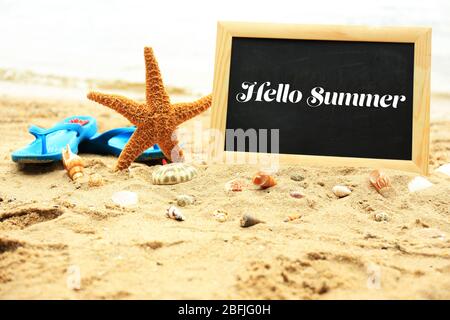 Hello summer concept. Chalkboard on beach background Stock Photo
