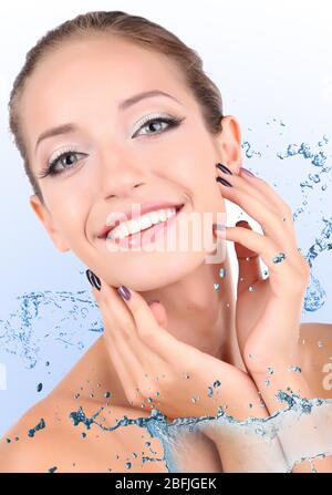 Beautiful young woman with water splashes close-up Stock Photo