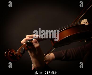 Violinist playing violin on dark background Stock Photo