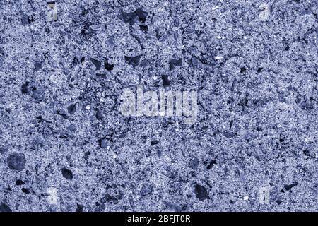 blue concrete wall interspersed with blue-tinged stone, scratches, structural background. Stock Photo