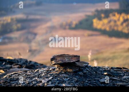 Caucasus, Georgia, Tusheti region, Omalo. Stones stacked on the ground with mountains in the background at dawn Stock Photo