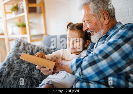 Grandparents playing and having fun with their granddaughter Stock Photo