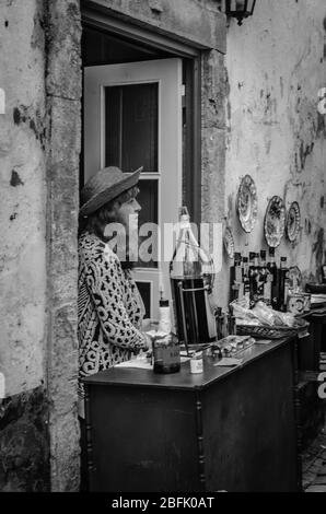 Young lady dispensing cherry liqueur known as Ginjinha Stock Photo