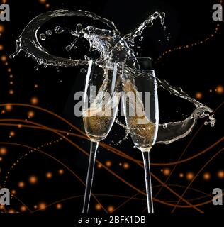 Glasses of champagne with splash, on black background Stock Photo