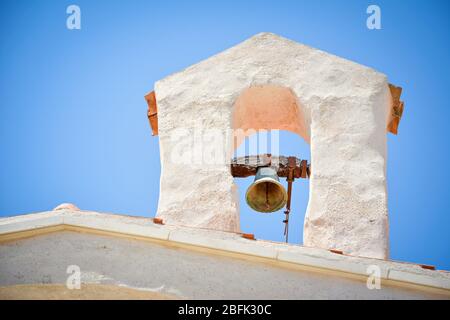 Cute ancient small bell tower with a bell upon a country church in a beautiful sunny day. Stock Photo