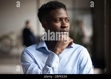 Thoughtful african American businessman look in distance pondering Stock Photo