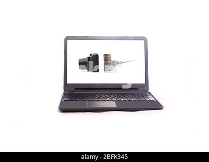Concept image of modern laptop showing camera and pile of coins, Photographed against white background. Stock Photo