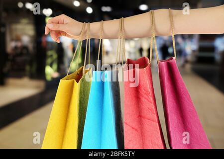 Female hand with shopping paper bags in market Stock Photo