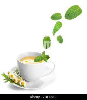 Mint leaves falling in cup of herbal tea, isolated on white Stock Photo