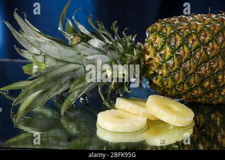 Big fresh pineapple close up on a water drops with small pineapple slices. Water splash . multivitamin cocktail. Pineapple juice. Healthy lifestyle. Stock Photo